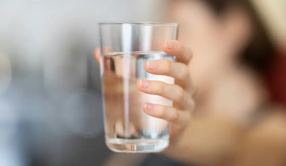 female hand holding a glass of water