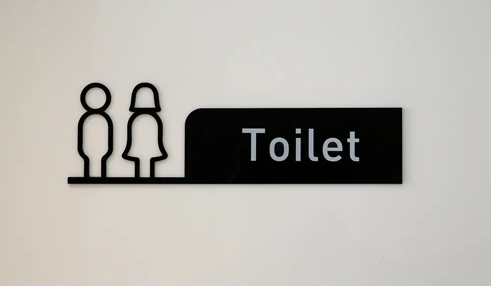 Mixed toilet sign on a white door