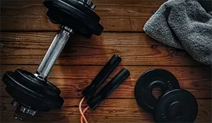 Dumbbell, Skipping rope and towel on a wooden table
