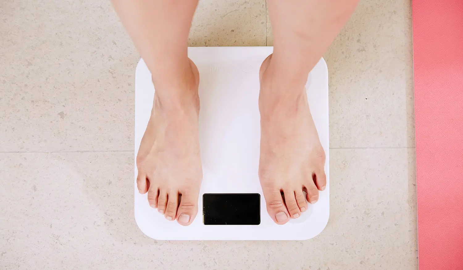 looking down at white weight scales as someone stands on them